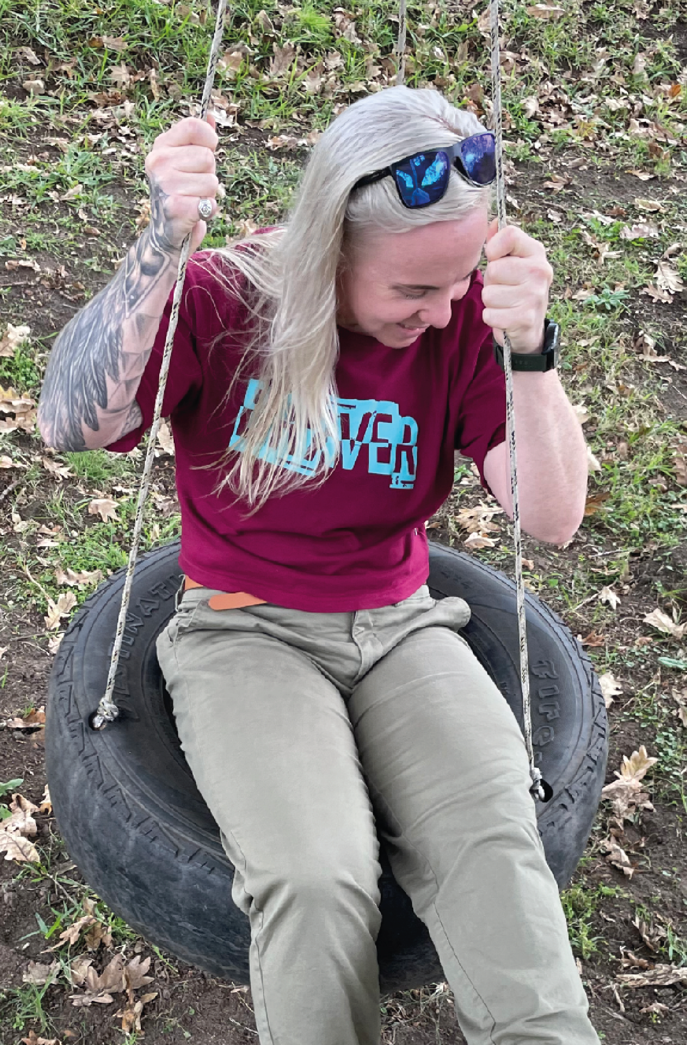 Women on a tyre swing wearing cargo pants with a maroon crop top