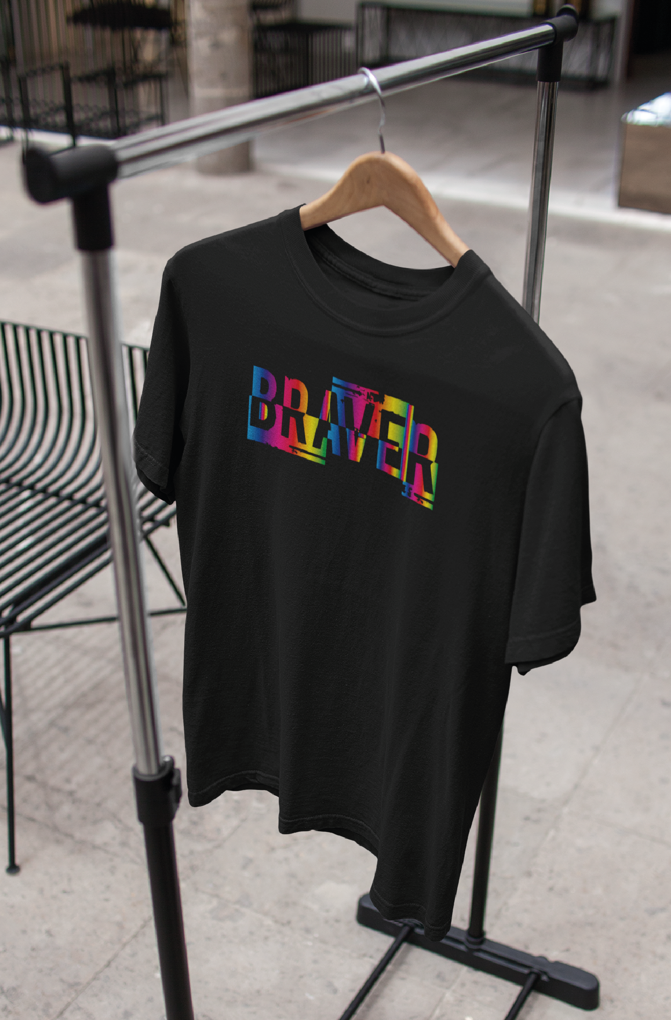 Black tshirt on a hanger with the word BRAVER printed in rainbow colours